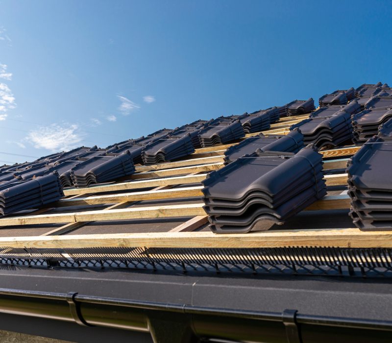 Roof ceramic tile arranged in packets on the roof on roof battens. Preparation for laying roof tiles